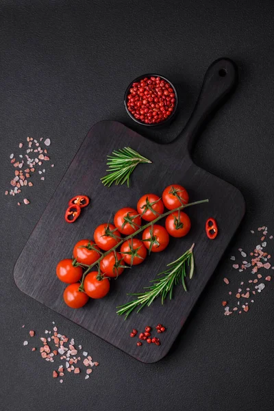 stock image Delicious fresh cherry tomatoes on a twig on a dark concrete background. Vegetarian cooking
