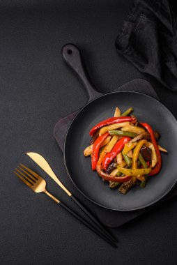 Lezzetli sebzeler biber buğulama, kuşkonmaz fasulye ve soya sosu dilimlenmiş patates koyu beton arka planda.