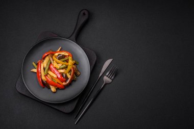 Lezzetli sebzeler biber buğulama, kuşkonmaz fasulye ve soya sosu dilimlenmiş patates koyu beton arka planda.