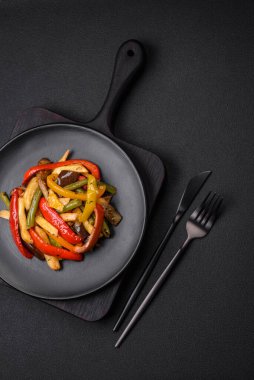 Lezzetli sebzeler biber buğulama, kuşkonmaz fasulye ve soya sosu dilimlenmiş patates koyu beton arka planda.