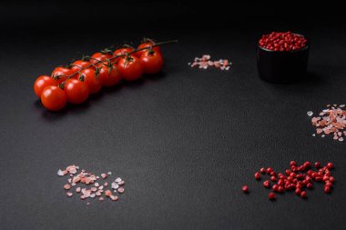 Taze vişneli domates salatası, tatlı biber, brokoli ve koyu beton arka planda tuz ve baharatlı karnabahar.