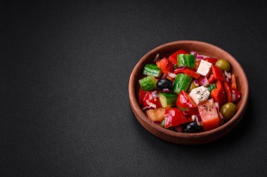 Lezzetli, feta peynirli taze Yunan salatası, zeytin, domates ve salatalık koyu beton arka planda.