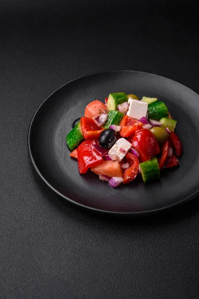 stock image Delicious, fresh Greek salad with feta cheese, olives, tomatoes and cucumbers on a dark concrete background