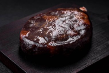 Lezzetli mahan, prosciutto ya da jamon. Koyu beton arka planda ahşap bir kesme tahtası.