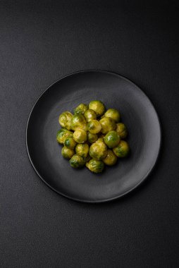 Lezzetli kaynamış Brüksel lahanaları, koyu beton arka planda seramik bir tabakta. Vejetaryen yemeği.