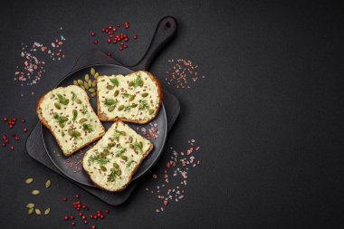 Avokado macunu, yumurta, krem peynir, tuz, baharat ve çimento kaplı bir masada ızgara tost.