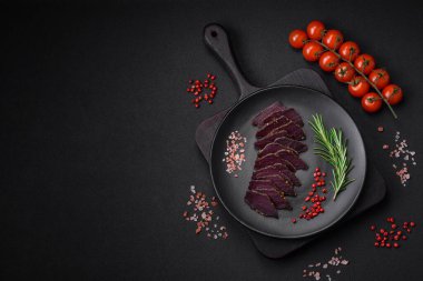 Lezzetli kurutulmuş biftek ya da at eti. Baharatlı kurutulmuş et ve koyu beton arka planda tuz.