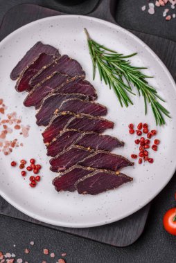 Lezzetli kurutulmuş biftek ya da at eti. Baharatlı kurutulmuş et ve koyu beton arka planda tuz.
