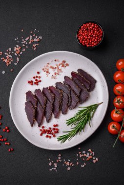 Lezzetli kurutulmuş biftek ya da at eti. Baharatlı kurutulmuş et ve koyu beton arka planda tuz.