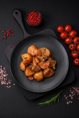 Lezzetli taze domuz etli yahni ya da koyu beton arka planda patates, havuç, baharat ve otlarla biftek.