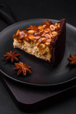 Lezzetli taze cheesecake keki ya da koyu beton arka planda seramik tabakta kremalı ve fındıklı snickers.