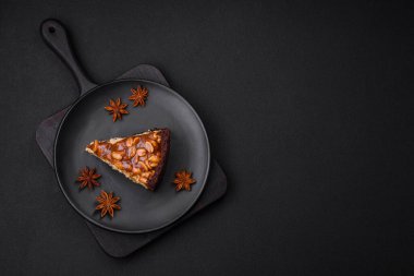 Lezzetli taze cheesecake keki ya da koyu beton arka planda seramik tabakta kremalı ve fındıklı snickers.