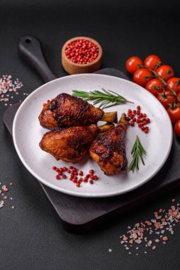 Lezzetli ızgara tavuk bacağı. Baharatlı ve otlu teriyaki soslu. Koyu beton arka planda.