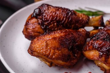 Lezzetli ızgara tavuk bacağı. Baharatlı ve otlu teriyaki soslu. Koyu beton arka planda.