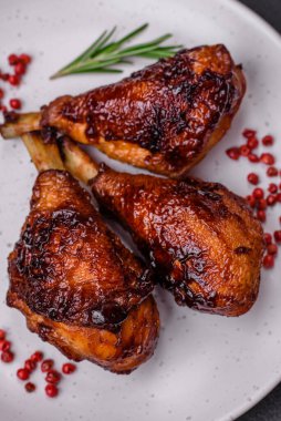 Lezzetli ızgara tavuk bacağı. Baharatlı ve otlu teriyaki soslu. Koyu beton arka planda.
