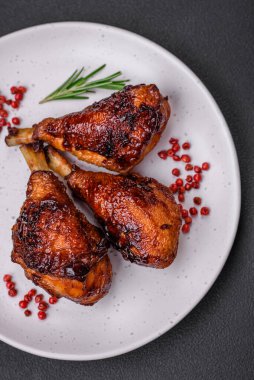 Lezzetli ızgara tavuk bacağı. Baharatlı ve otlu teriyaki soslu. Koyu beton arka planda.