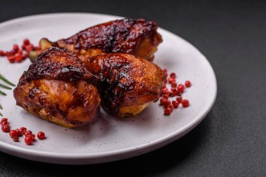 Lezzetli ızgara tavuk bacağı. Baharatlı ve otlu teriyaki soslu. Koyu beton arka planda.
