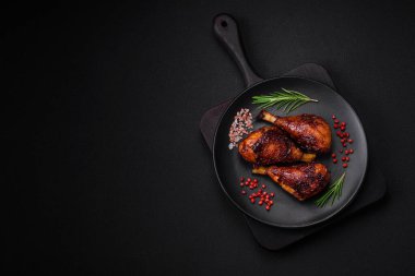 Lezzetli ızgara tavuk bacağı. Baharatlı ve otlu teriyaki soslu. Koyu beton arka planda.