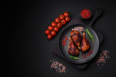 Lezzetli ızgara tavuk bacağı. Baharatlı ve otlu teriyaki soslu. Koyu beton arka planda.