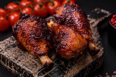 Lezzetli ızgara tavuk bacağı. Baharatlı ve otlu teriyaki soslu. Koyu beton arka planda.