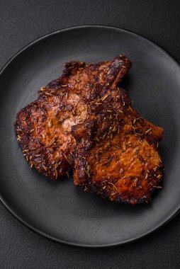 Lezzetli biftek ya da kemikte ızgara biftek, baharat ve koyu beton arka planda biberiye.