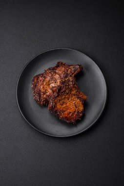 Lezzetli biftek ya da kemikte ızgara biftek, baharat ve koyu beton arka planda biberiye.