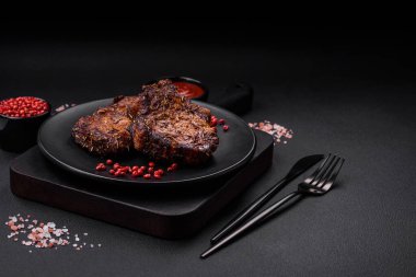 Lezzetli biftek ya da kemikte ızgara biftek, baharat ve koyu beton arka planda biberiye.