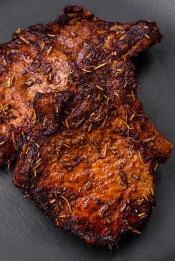 Lezzetli biftek ya da kemikte ızgara biftek, baharat ve koyu beton arka planda biberiye.