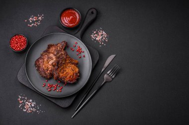 Lezzetli biftek ya da kemikte ızgara biftek, baharat ve koyu beton arka planda biberiye.