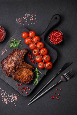 Lezzetli biftek ya da kemikte ızgara biftek, baharat ve koyu beton arka planda biberiye.