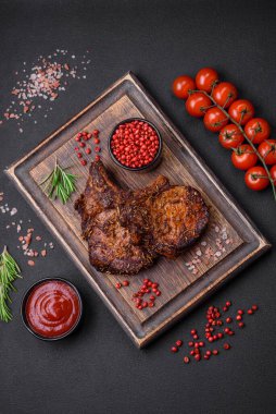 Lezzetli biftek ya da kemikte ızgara biftek, baharat ve koyu beton arka planda biberiye.