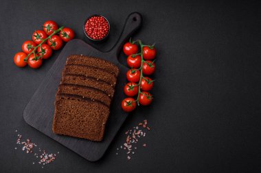 Tahta kesme tahtasına kesilmiş tahıllı ve tohumlu lezzetli kahverengi ekmek.