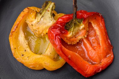 Lezzetli ızgara biber, baharat ve otlarla birlikte koyu beton bir arka planda.