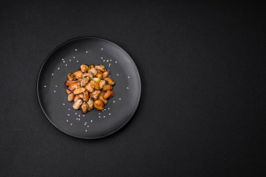 Çimento arka planında seramik tabakta baharat ve otlarla marine edilmiş lezzetli midyeler.