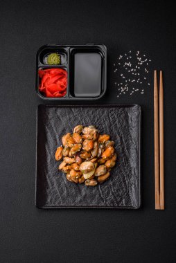 Çimento arka planında seramik tabakta baharat ve otlarla marine edilmiş lezzetli midyeler.