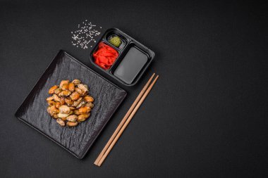 Çimento arka planında seramik tabakta baharat ve otlarla marine edilmiş lezzetli midyeler.