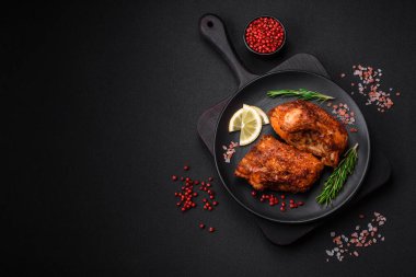 Lezzetli kızarmış levrek balığı. Koyu beton arka planda seramik bir tabakta baharat ve otlarla dilimler halinde.