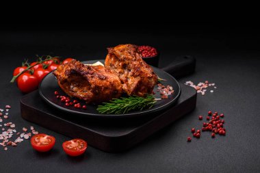 Lezzetli kızarmış levrek balığı. Koyu beton arka planda seramik bir tabakta baharat ve otlarla dilimler halinde.