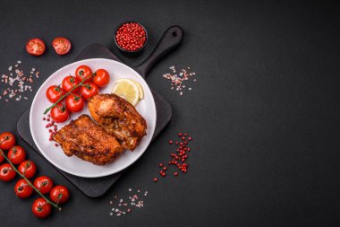 Lezzetli kızarmış levrek balığı. Koyu beton arka planda seramik bir tabakta baharat ve otlarla dilimler halinde.