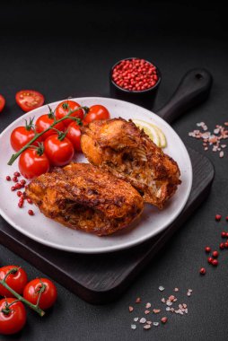 Lezzetli kızarmış levrek balığı. Koyu beton arka planda seramik bir tabakta baharat ve otlarla dilimler halinde.