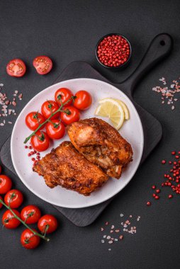 Lezzetli kızarmış levrek balığı. Koyu beton arka planda seramik bir tabakta baharat ve otlarla dilimler halinde.