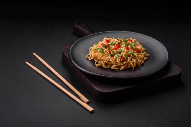 Sebzeli, tuzlu, baharatlı ve çimento kaplı seramik bir tabakta taze Asya eriştesi.