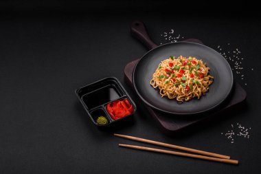 Sebzeli, tuzlu, baharatlı ve çimento kaplı seramik bir tabakta taze Asya eriştesi.