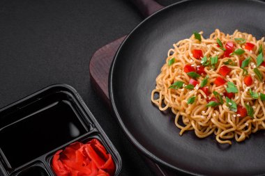 Sebzeli, tuzlu, baharatlı ve çimento kaplı seramik bir tabakta taze Asya eriştesi.