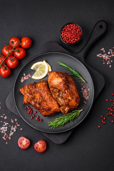 stock image Delicious fried sea bass fish in the form of slices with spices and herbs on a ceramic plate on a dark concrete background