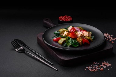 Lezzetli taze kabak salatası, peynir, tatlı biber, baharatlı ıspanak ve çimento kaplı seramik tabakta otlar.