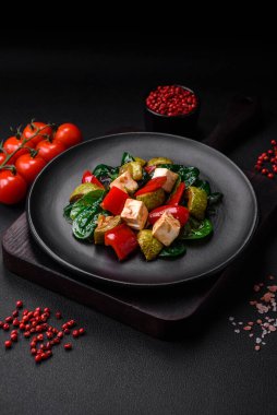 Lezzetli taze kabak salatası, peynir, tatlı biber, baharatlı ıspanak ve çimento kaplı seramik tabakta otlar.