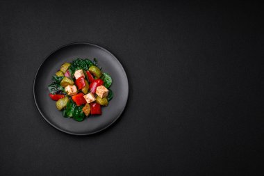 Lezzetli taze kabak salatası, peynir, tatlı biber, baharatlı ıspanak ve çimento kaplı seramik tabakta otlar.