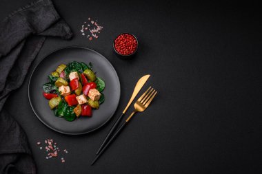 Lezzetli taze kabak salatası, peynir, tatlı biber, baharatlı ıspanak ve çimento kaplı seramik tabakta otlar.