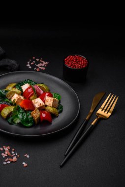 Lezzetli taze kabak salatası, peynir, tatlı biber, baharatlı ıspanak ve çimento kaplı seramik tabakta otlar.